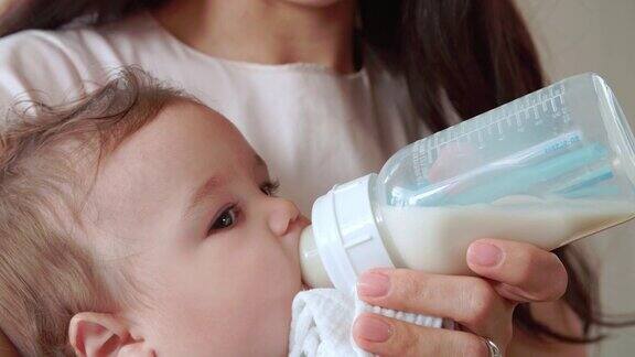 母亲在家用奶瓶喂男婴