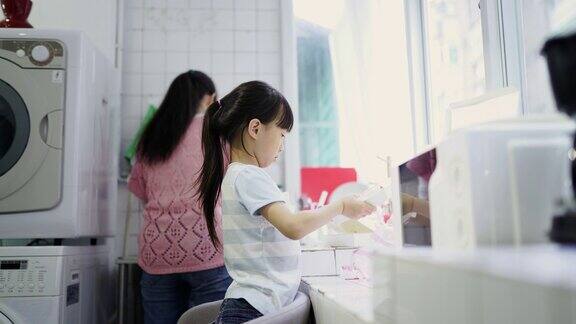 小女孩在厨房里帮妈妈干活
