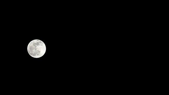 月亮时间推移库存时间推移:满月上升在黑暗的自然天空夜晚的时间满月盘的时间随着月亮照亮了夜晚漆黑的天空高质量的免费视频素材或时间间隔