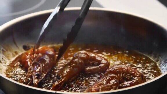 厨师用钳子把虾放在烤架上烤大虾在平底锅里煎的特写厨师在热锅上煎皇家虾大型海鲜制备