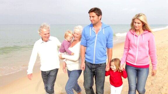 多代家庭一起在沙滩上散步