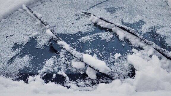 雨刷片清洁汽车的挡风玻璃上的雪冬季暴风雪给汽车结冰