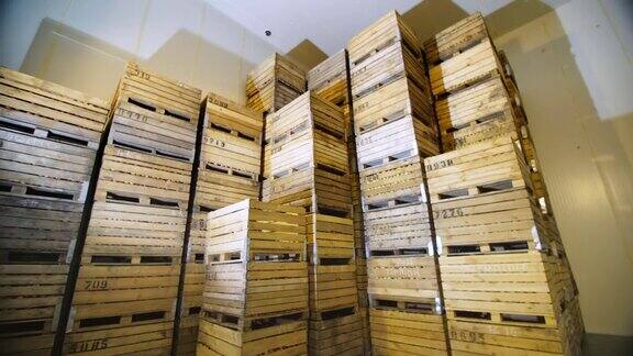 苹果存储仓库一堆堆装水果的木箱冷藏仓库里装着苹果的箱子仓库里巨大的冰箱不透气的储存摄像头苹果丰收