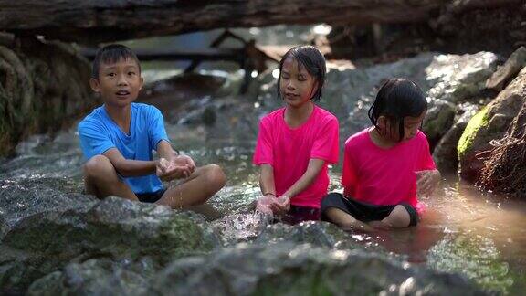 孩子们在瀑布上游玩旅游暑假亚洲快乐的孩子们在大自然中旅行