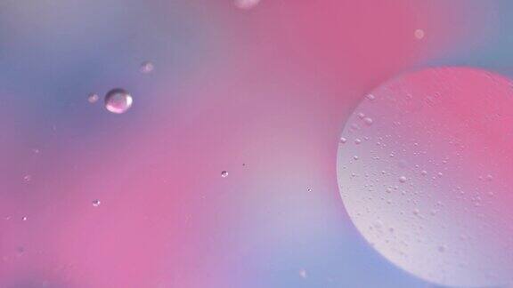宏观油滴在水里粉色和蓝色柔和的颜色梯度的液体