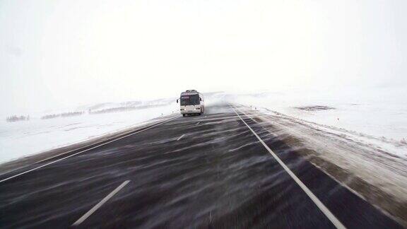 汽车行驶在积雪覆盖的公路上带有拖车的重型卡车运载货物