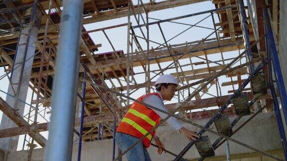 亚洲工程师走上建筑工地的楼梯
