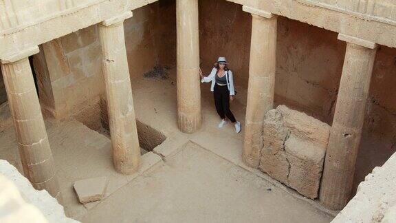 一个女人走在古庙的废墟上