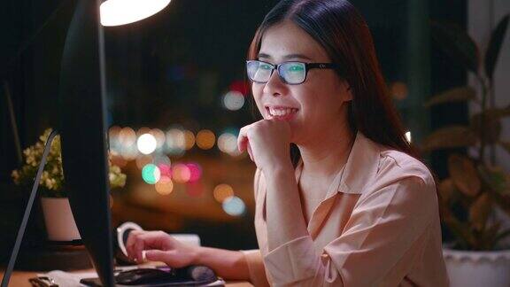 年轻女子笑着看电脑屏幕的夜晚
