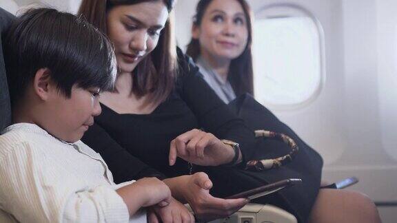 男孩和妈妈在飞机上玩手机