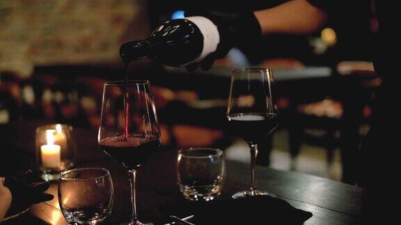高档餐厅里一名不知名的男侍酒师正在往杯子里倒红酒