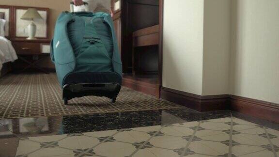 低角度:一个年轻的女人拿着她的旅行袋走进她美丽的酒店房间