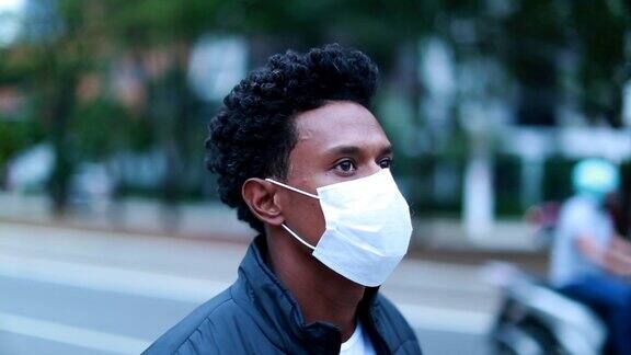 自信的黑人戴着面具走在城市的人行道上