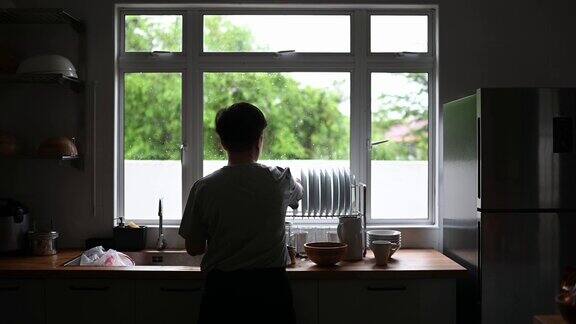 一个在厨房洗盘子的亚洲华人妇女