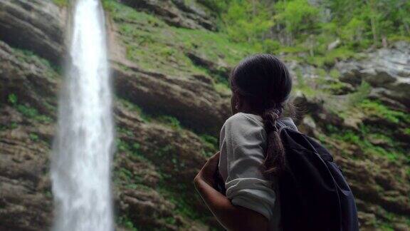 年轻女子指着瀑布