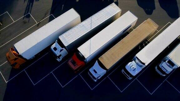 空中鸟瞰图的白色半挂车与其他卡车的货物拖车停车场在特殊停车场