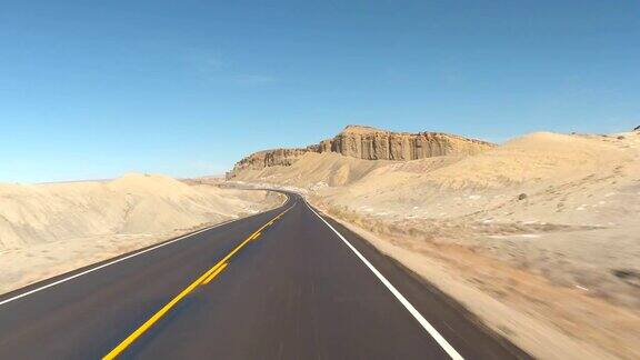 FPVHYPERLAPSE在灰色的沙漠峡谷中沿着空旷的道路行驶