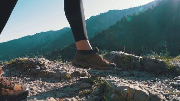 在山崖上徒步旅行的女旅行者的脚上的观点慢动作