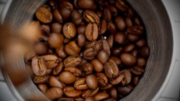 将烘好的咖啡豆倒入咖啡研磨机特写镜头