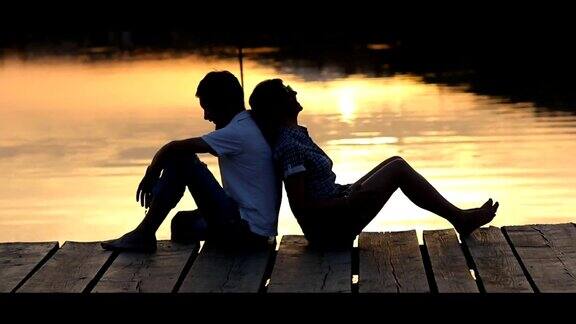 一对夫妇在湖边码头欣赏日落