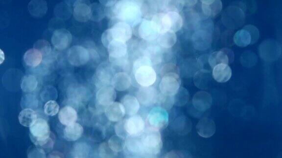 蓝色水中闪烁粒子的抽象背景环