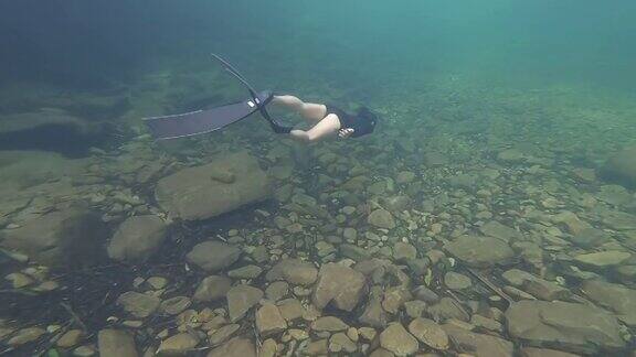 亚洲女子自由潜水在清澈的水
