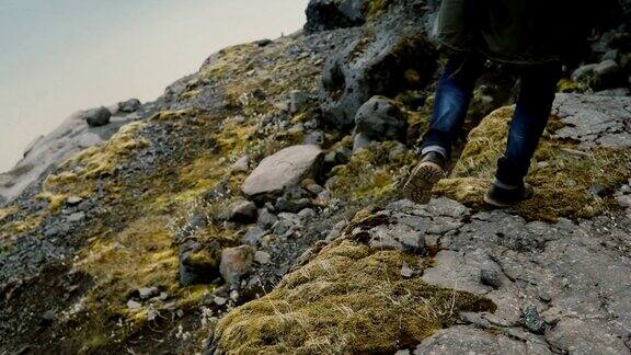 年轻英俊的男子正在穿过冰岛Vatnajokull冰礁附近山上的岩石