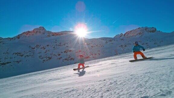 SLOMOTS夫妇骑着滑雪板滑下阳光明媚的山坡