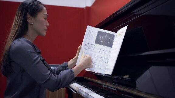 亚洲妇女在家练习钢琴
