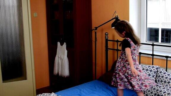 可爱的小女孩在床上跳舞缓慢的运动童年
