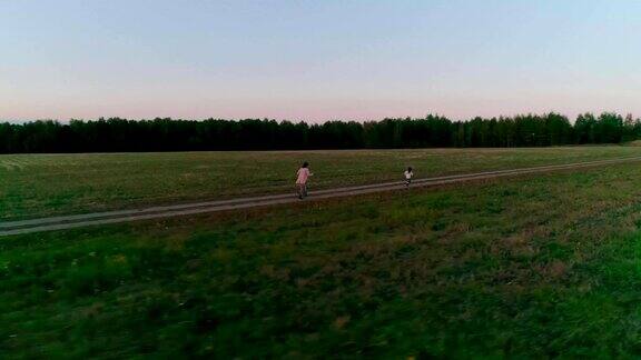 夕阳下母亲带着女儿在乡间小路上奔跑