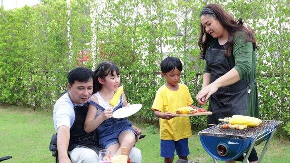 家庭露营和烹饪烧烤派对快乐的亚洲家庭在家里享受烧烤露营