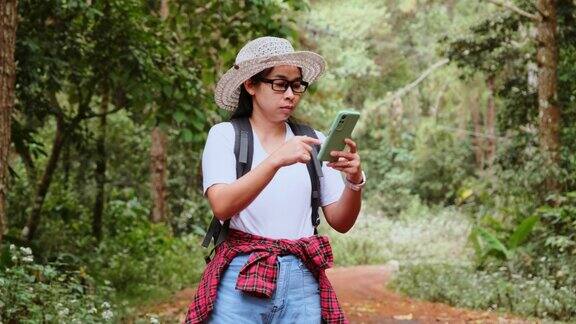 女性旅行者在热带森林背包旅行时使用智能手机定位和导航