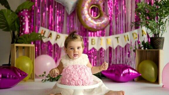 可爱的小女孩吃蛋糕庆祝他的一岁生日