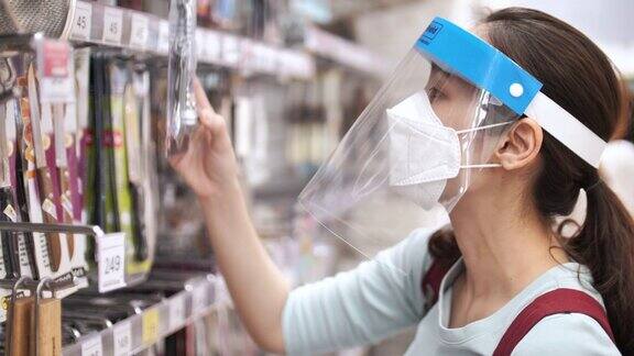 亚洲妇女戴口罩和面罩在超市购物新冠肺炎后的正常生活