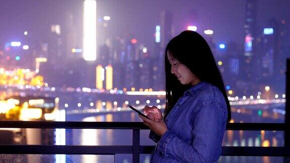 年轻女子在晚上使用手机