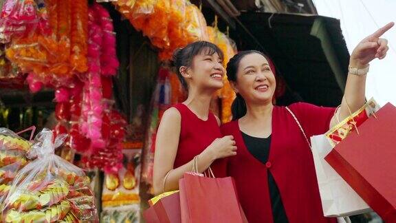 4K亚洲母亲和女儿在唐人街购买庆祝中国农历新年的商品