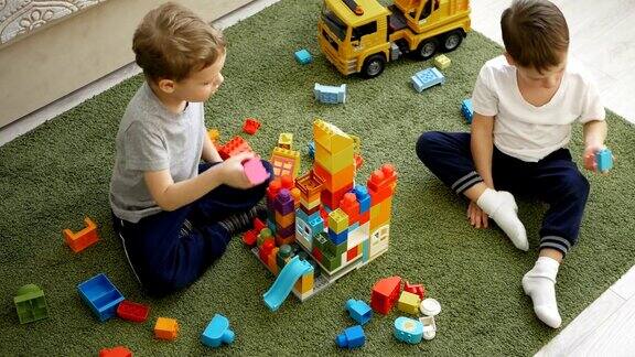 两个小男孩在地板上玩彩色积木