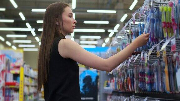 年轻女子在超市购物选择牙刷