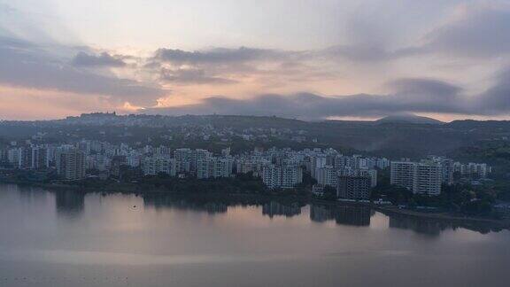 美丽的时间流逝的太阳升起背后的山脉和城市景观湖前的一个印度城市印度