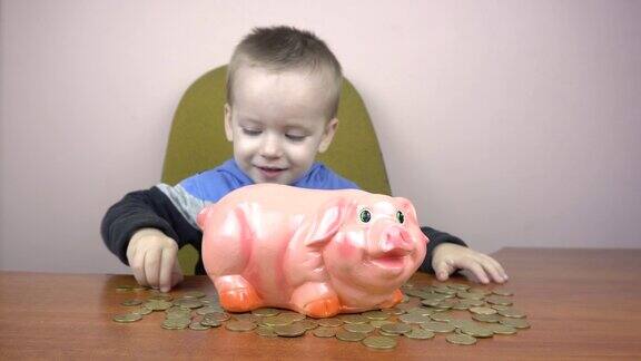 快乐的小男孩把硬币扔进一个小猪储蓄罐省钱