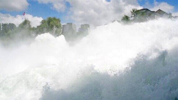 一个美丽的风景流动强大的瀑布在背景飘扬的瑞士国旗在瑞士的莱茵河纽豪森瀑布