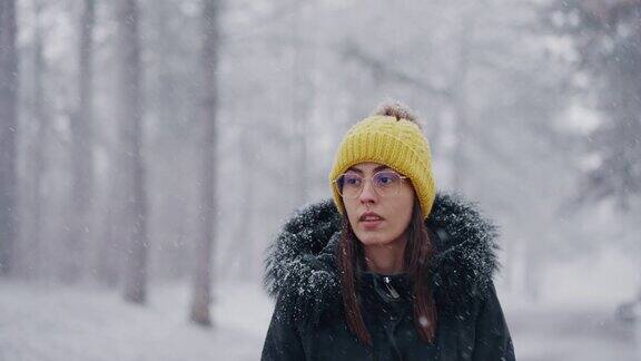 一位年轻女子正在享受下雪天散步的乐趣