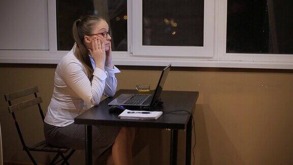 疲惫的商务女性带着眼镜在办公室的笔记本电脑工作到深夜学习到深夜熬夜超负荷工作