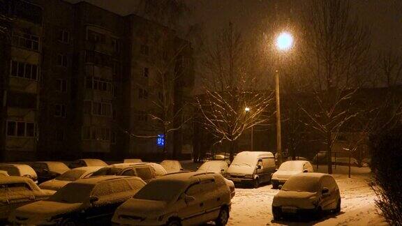 雪覆盖了晚上留在停车场的汽车