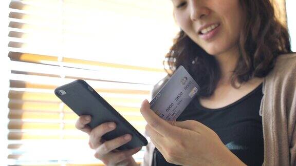 购物女人拿着智能手机和信用卡进行网上购物