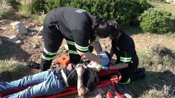 两名女医护人员协助一名伤者