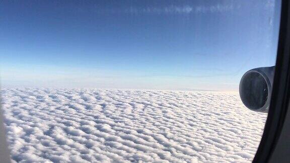 飞行时借助飞机叶片发动机透过飞机窗座看到多云蓝天