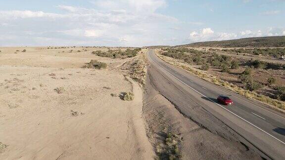 黄昏时分在戏剧化的天空下慢动作半卡车在犹他州沙漠的高速公路上超速行驶