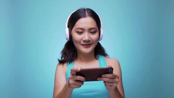 女人玩游戏与智能手机上孤立的蓝色4k背景